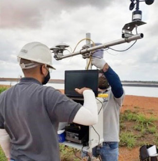 A technical team works with a weather and solar radiation monitoring station. A technical team works with a weather and solar radiation monitoring station.