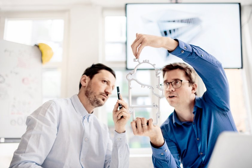 Two men viewing an extruded aluminium profile
