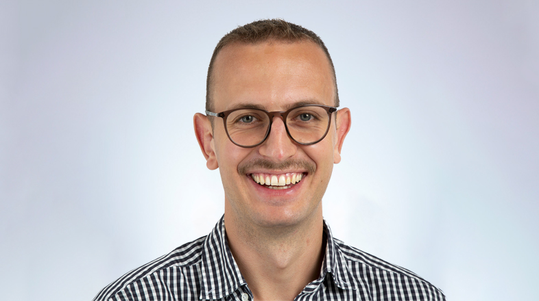 a man wearing glasses smiling