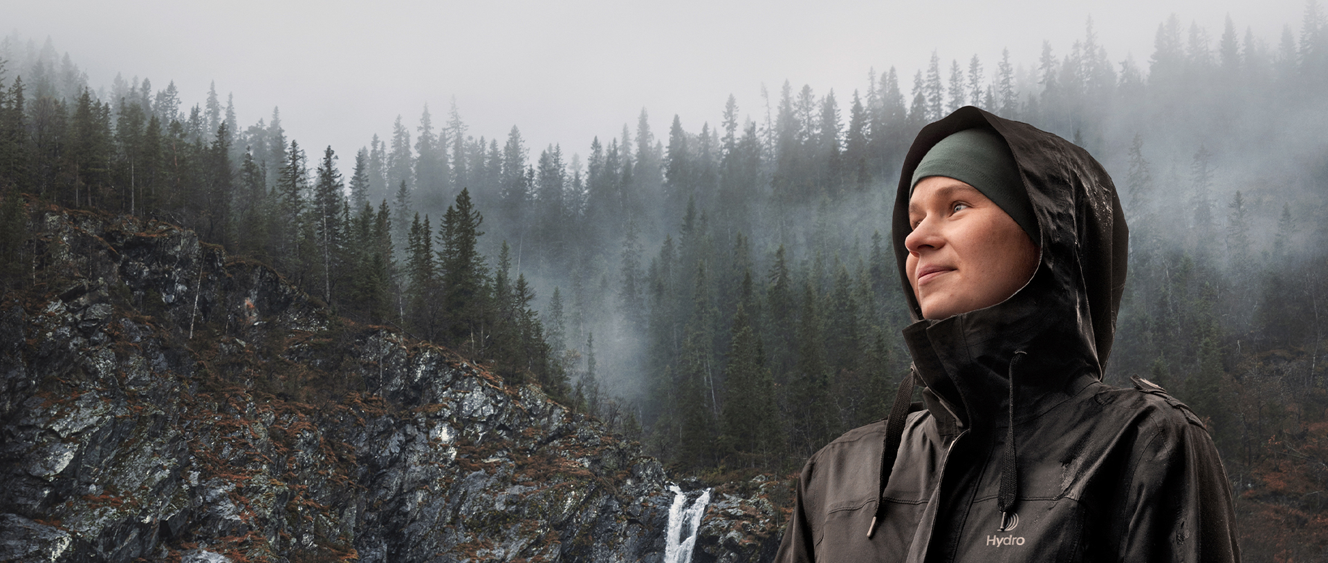 a woman wearing a hoodie and standing on a snowy hill