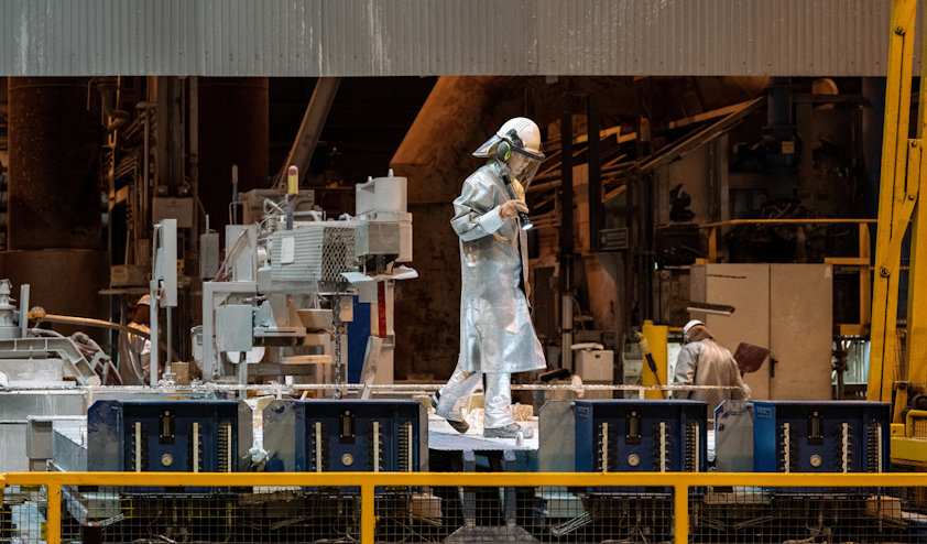 a person in a silver suit working on a machine a person in a silver suit working on a machine