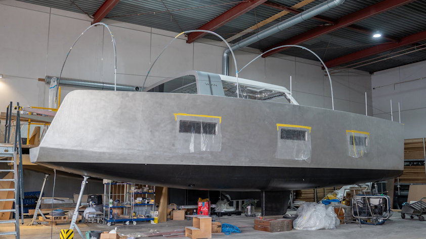 a grey boat hull in a factory a grey boat hull in a factory