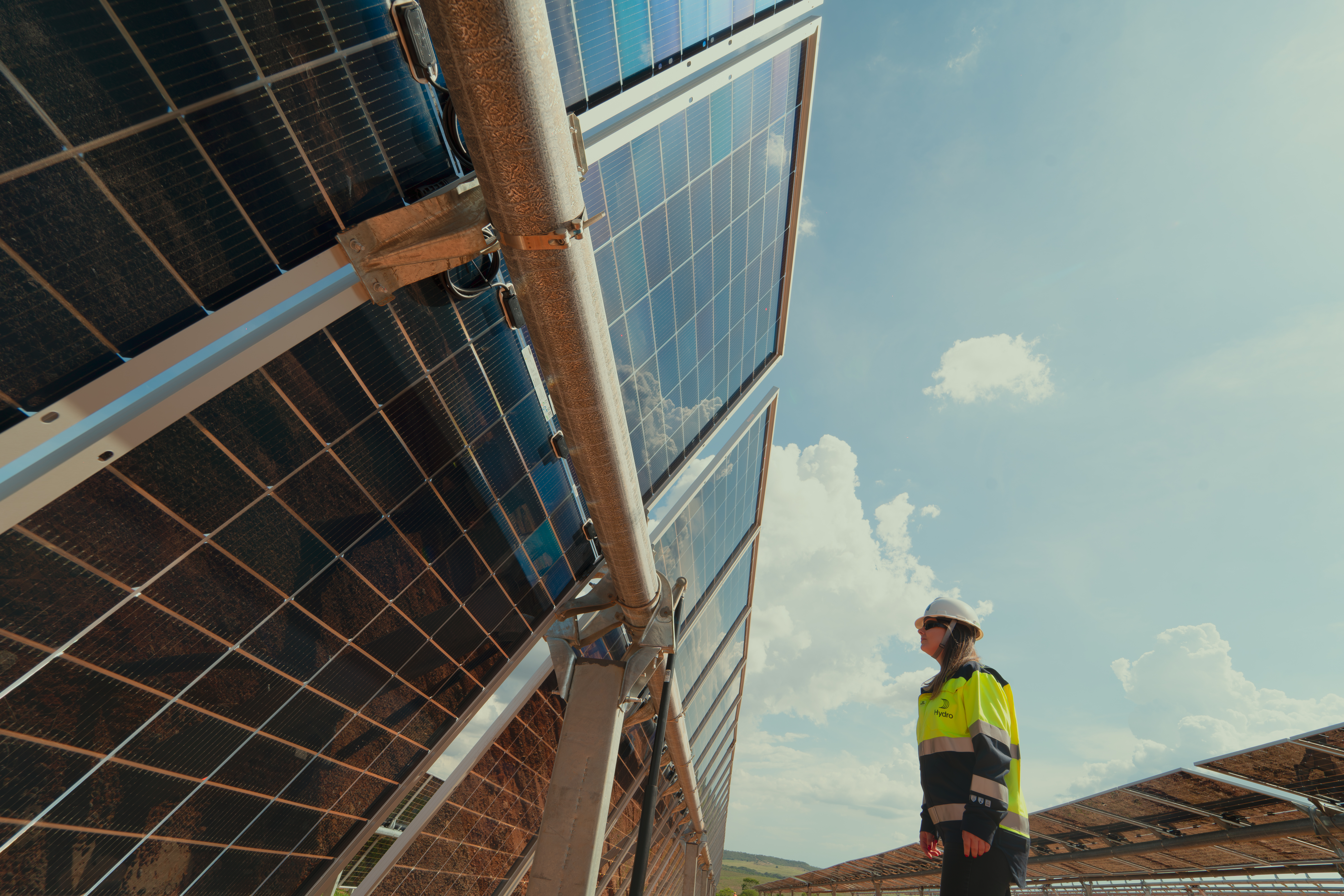 a woman standing next to solar panels