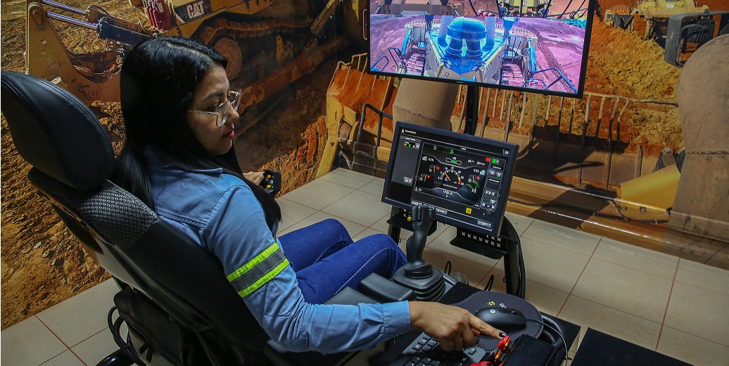 a person sitting in a chair with a computer and a game on the screen