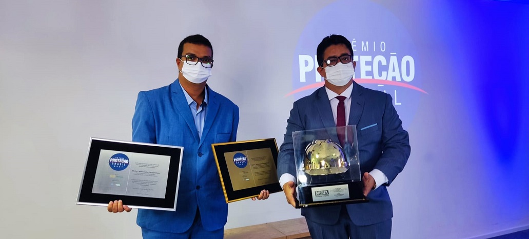 a couple of men holding awards