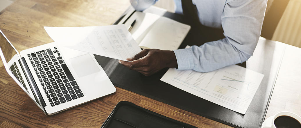 Business man working at office with laptop and documents on his desk