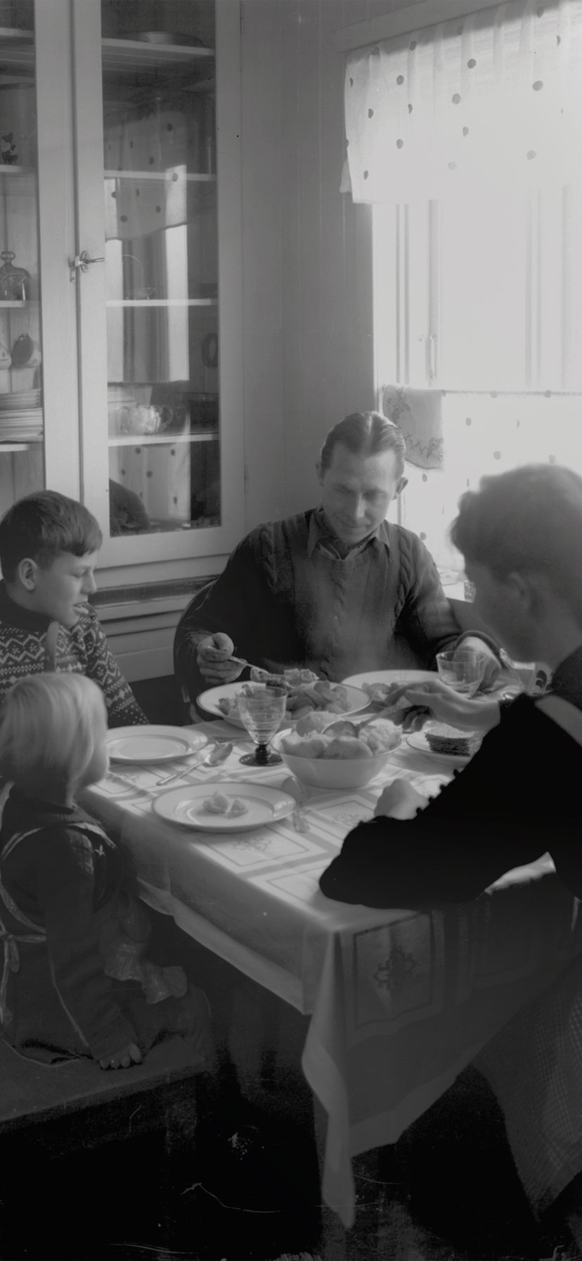 Familie spiser middag ved kjøkkenbordet