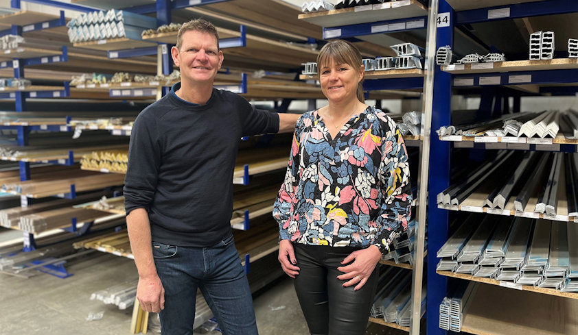 a man and woman posing for a picture in a warehouse