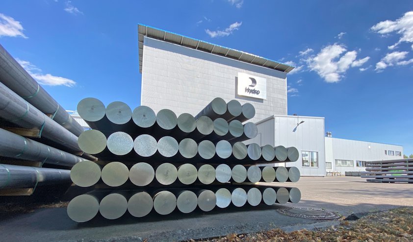 a large building with a large stack of aluminium ingots in front of it a large building with a large stack of aluminium ingots in front of it