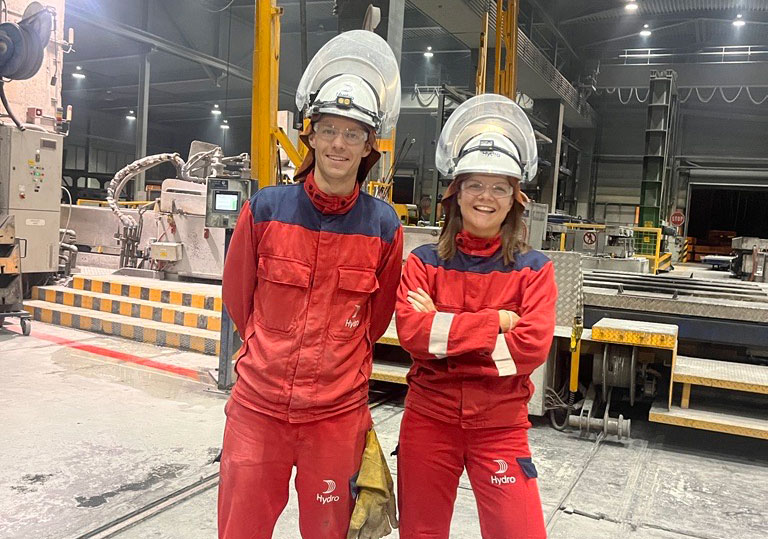 a couple of women in red jumpsuits in a factory