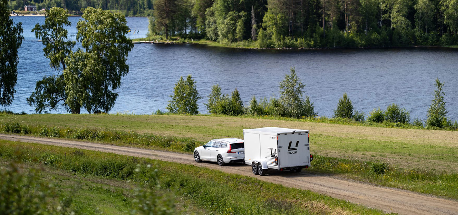 a white car next to a trailer